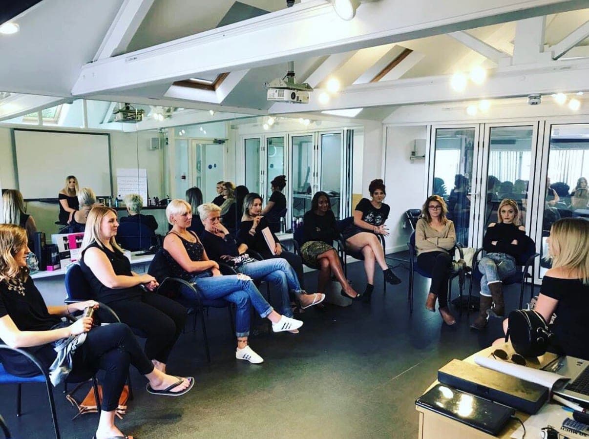 Amanda teaching a room of seated hairdressers at a professional education session